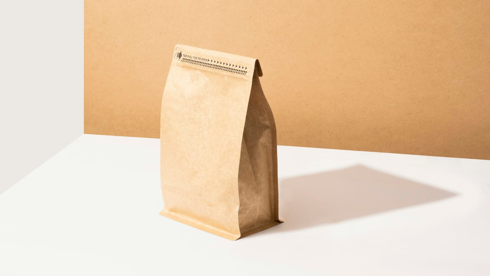 Embalagem de café de papel kraft com fecho e válvula, em pé sobre uma mesa clara