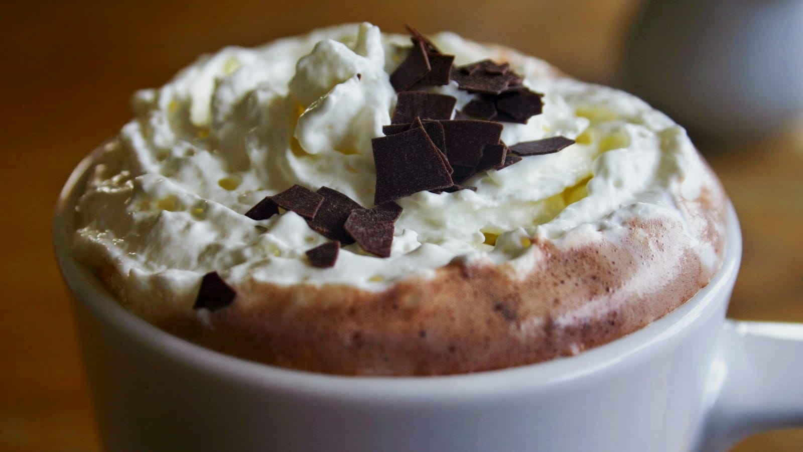 Caneca branca com mocha coberto de chantili e lascas de chocolate